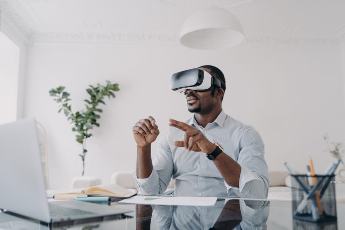 African,American,Businessman,Using,Virtual,Reality,Glasses,Sitting,At,Laptop